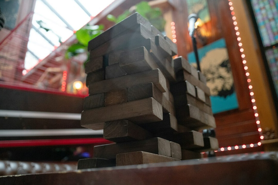 Hands stacking wooden blocks together on a table